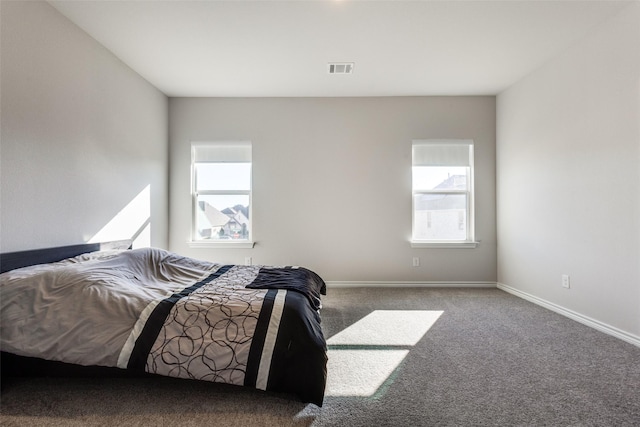 carpeted bedroom with visible vents and baseboards