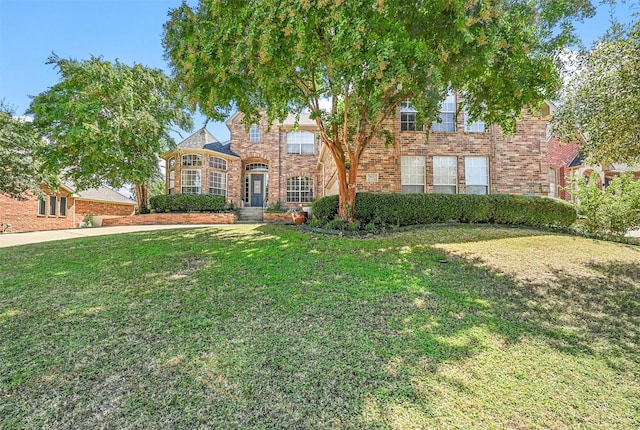 view of front of property featuring a front yard and brick siding