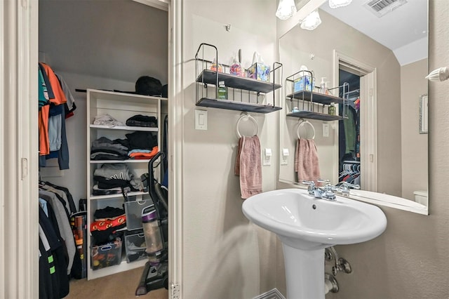 bathroom with visible vents and a walk in closet