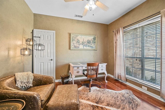 living area with baseboards, plenty of natural light, visible vents, and wood finished floors