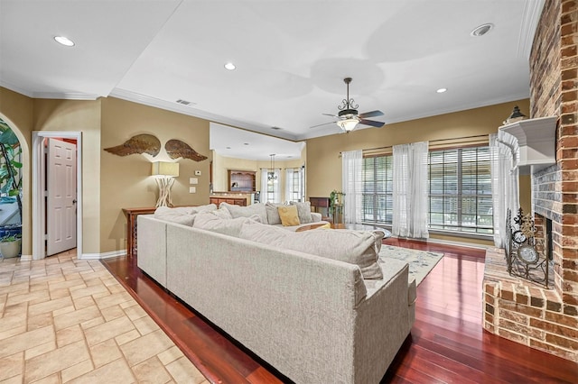 living area with ornamental molding, recessed lighting, and a fireplace