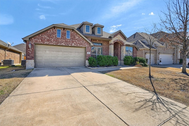 view of front of house featuring brick siding, a shingled roof, an attached garage, central AC, and driveway