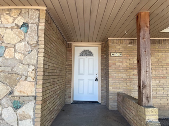 entrance to property featuring brick siding