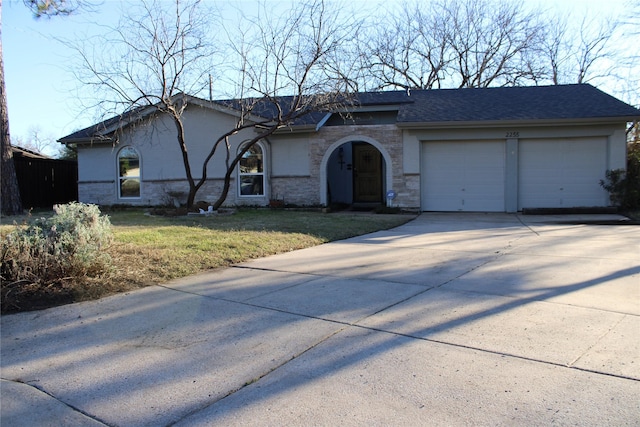 view of front of property with roof with shingles, stucco siding, concrete driveway, an attached garage, and a front yard