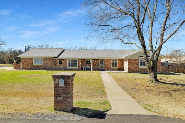 single story home with brick siding, a front lawn, and fence