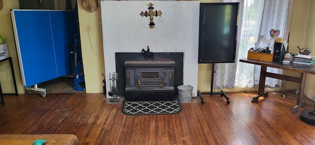 living area featuring a wood stove and wood finished floors