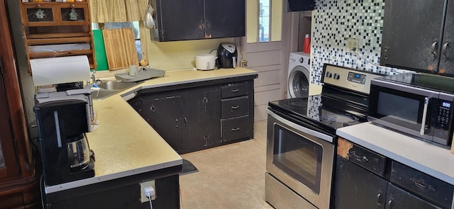 kitchen featuring stainless steel appliances, light countertops, washer / dryer, and dark cabinetry