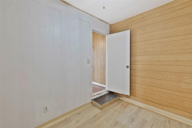 unfurnished room featuring wooden walls and wood finished floors