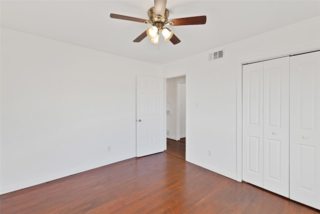 unfurnished bedroom featuring a closet, visible vents, ceiling fan, wood finished floors, and baseboards