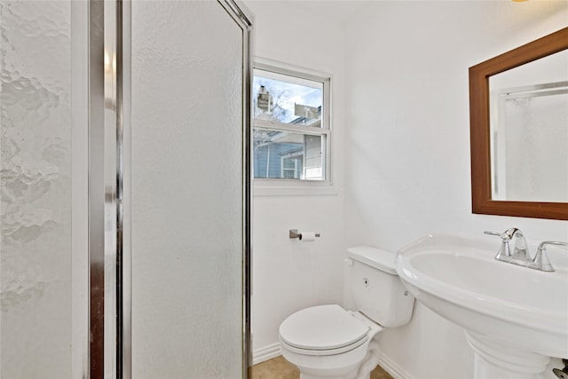 bathroom with baseboards, a sink, and toilet