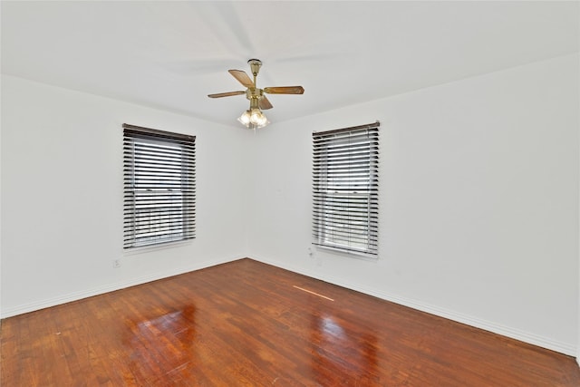 spare room featuring wood-type flooring, baseboards, and ceiling fan