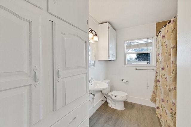 full bathroom featuring baseboards, a sink, toilet, and wood finished floors