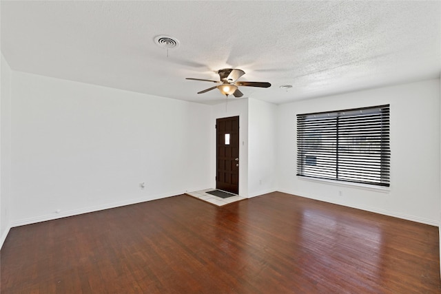 unfurnished room with visible vents, ceiling fan, baseboards, and wood finished floors