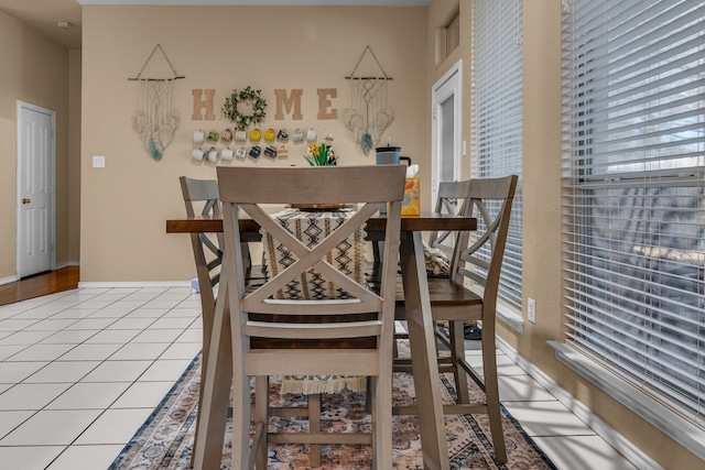 dining area featuring light tile patterned flooring and baseboards