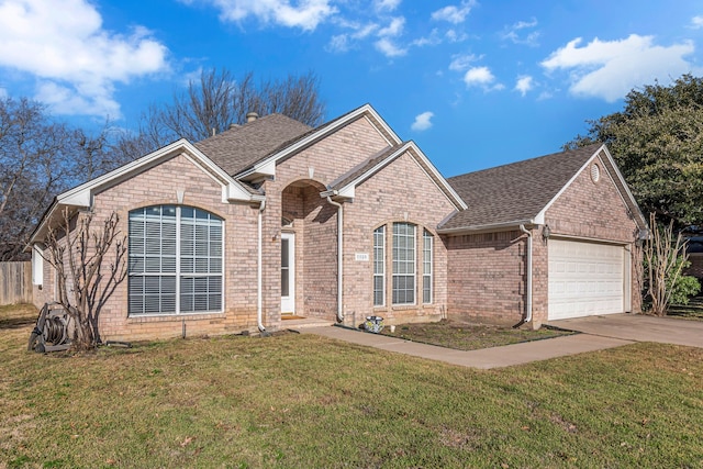 ranch-style house featuring brick siding, a shingled roof, concrete driveway, an attached garage, and a front yard