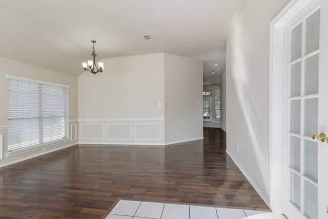 living room with an inviting chandelier, baseboards, visible vents, and wood finished floors