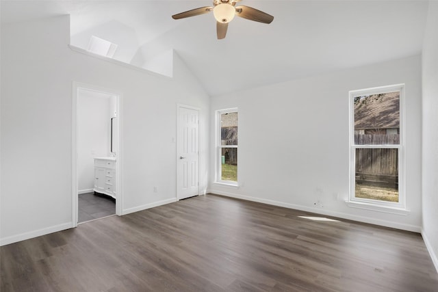 unfurnished bedroom featuring baseboards, dark wood finished floors, a ceiling fan, ensuite bath, and vaulted ceiling