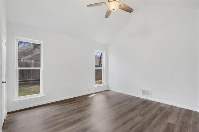 spare room featuring dark wood-style floors, visible vents, and a wealth of natural light