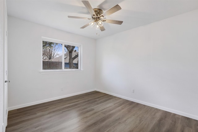 spare room featuring a ceiling fan, baseboards, and wood finished floors