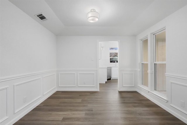 spare room featuring visible vents and dark wood finished floors