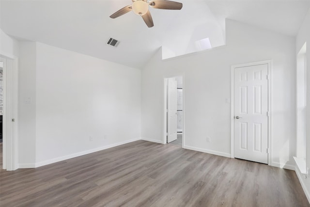 empty room with baseboards, visible vents, a ceiling fan, lofted ceiling, and wood finished floors