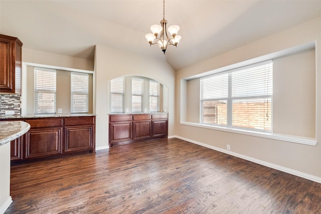 kitchen with plenty of natural light, a chandelier, and dark wood-type flooring