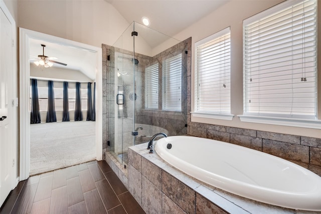 bathroom featuring a wealth of natural light, a garden tub, vaulted ceiling, and a shower stall