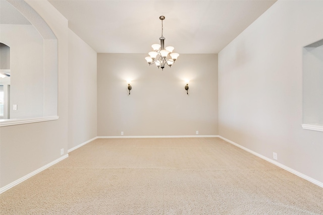 empty room with baseboards, arched walkways, and a notable chandelier