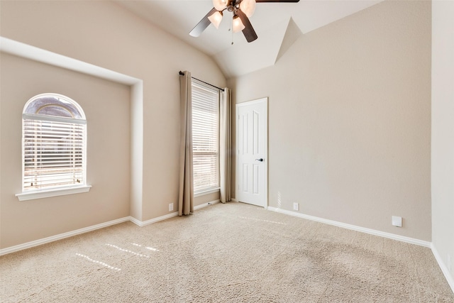 empty room with carpet floors, lofted ceiling, ceiling fan, and baseboards