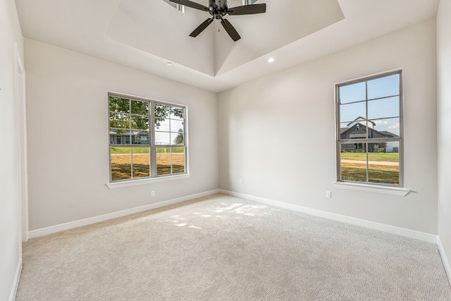 carpeted empty room with a ceiling fan, a tray ceiling, baseboards, and recessed lighting