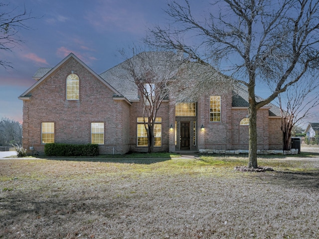 view of front of home with brick siding and a front lawn