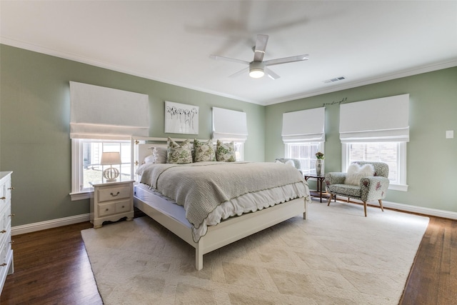 bedroom with baseboards, visible vents, and wood finished floors