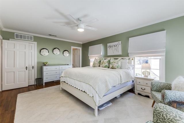 bedroom featuring visible vents, crown molding, and wood finished floors