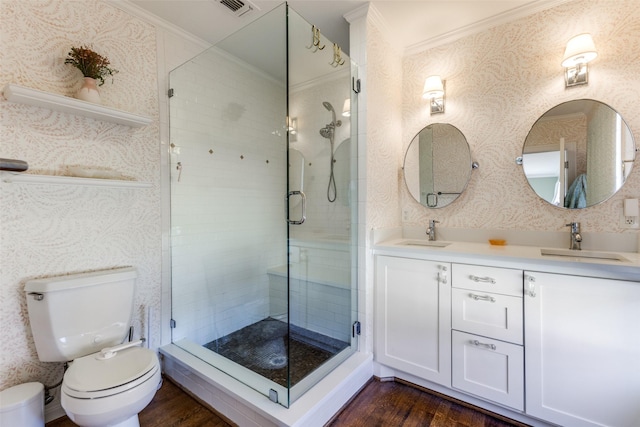 bathroom with a sink, a shower stall, and wallpapered walls