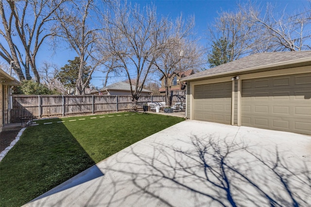 view of yard featuring a garage, an outbuilding, and fence private yard