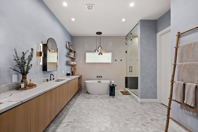 bathroom featuring a stall shower, visible vents, vanity, a freestanding tub, and recessed lighting