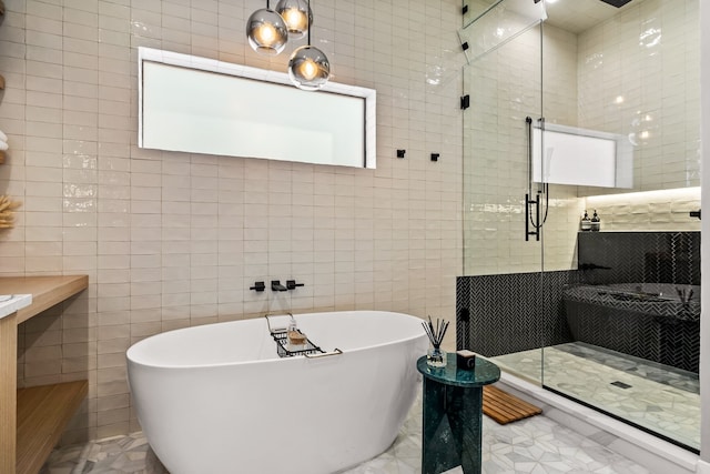 full bath featuring a freestanding tub, a tile shower, and tile walls