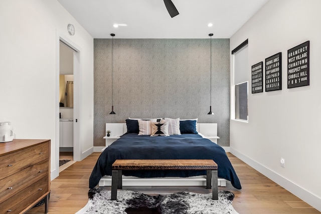 bedroom featuring recessed lighting, an accent wall, wood finished floors, a ceiling fan, and baseboards