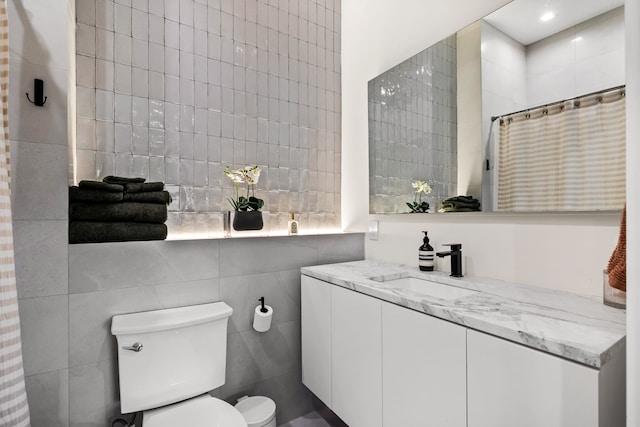 full bath featuring a shower with curtain, tile walls, toilet, and vanity