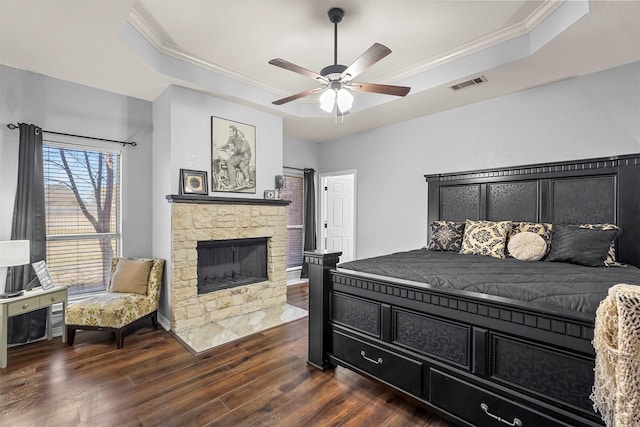 bedroom with crown molding, a raised ceiling, visible vents, and dark wood finished floors