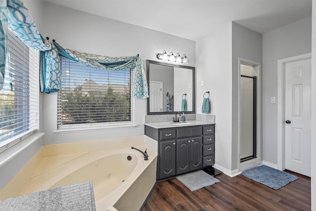 full bathroom with a whirlpool tub, a stall shower, wood finished floors, and vanity