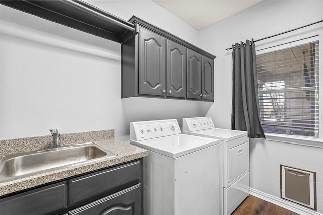 laundry room featuring cabinet space, dark wood finished floors, a sink, and independent washer and dryer