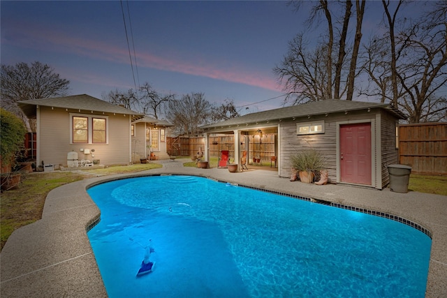 view of swimming pool featuring an outbuilding, a patio area, a fenced backyard, and a fenced in pool