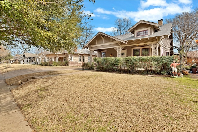 craftsman house with a front lawn and a chimney