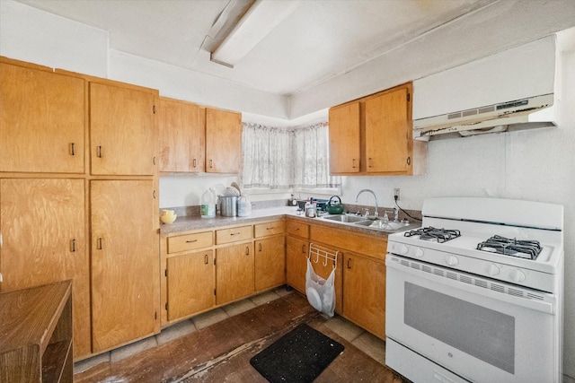 kitchen with white range with gas stovetop, light countertops, and a sink