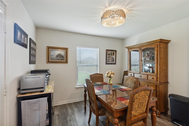 dining space with baseboards and wood finished floors