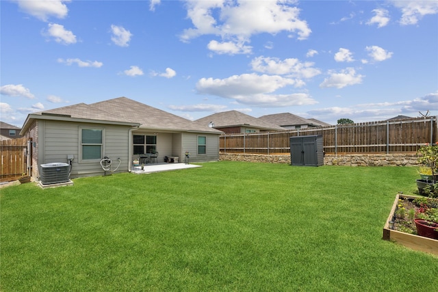 view of yard with a garden, a fenced backyard, a patio area, and central AC unit