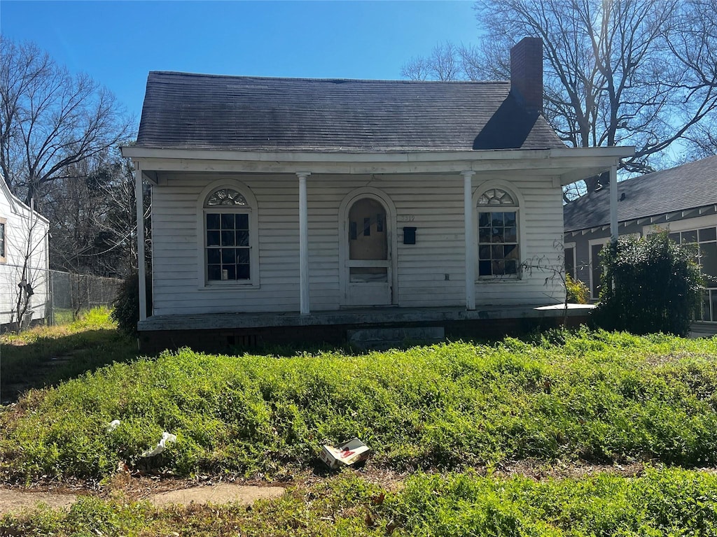 bungalow-style home with a porch and a chimney