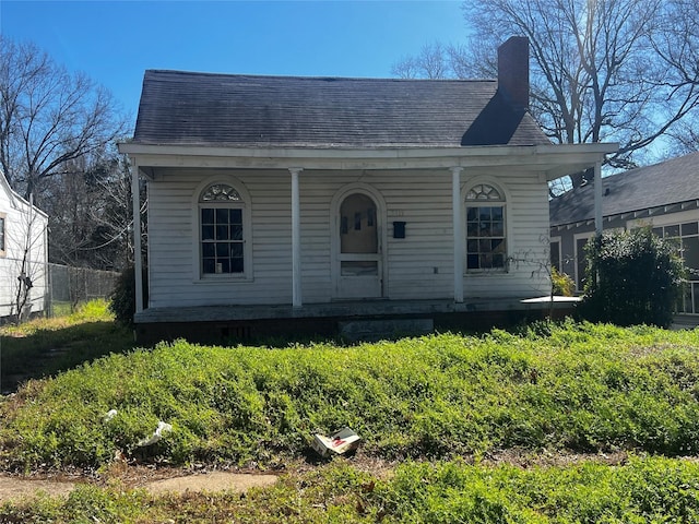 bungalow-style home with a porch and a chimney