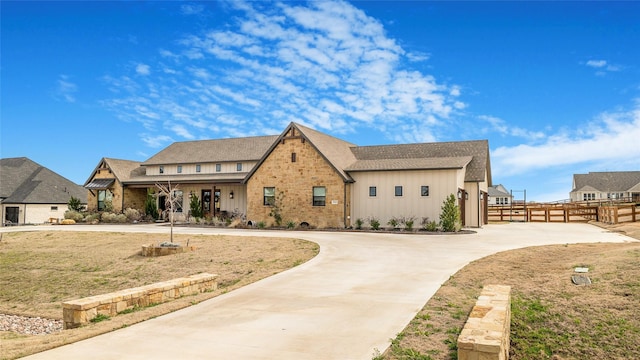 view of front of property featuring board and batten siding, a gate, driveway, and fence